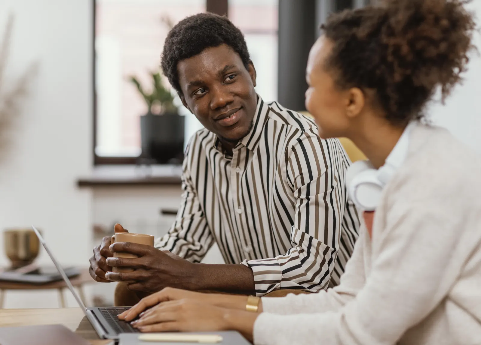 Two colleagues talking over a laptop